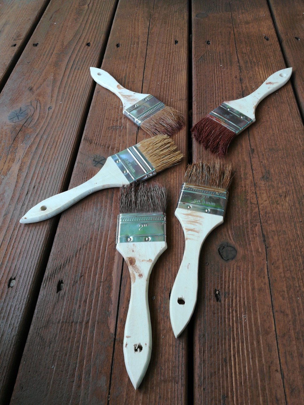 Paint brushes arranged on stained wood